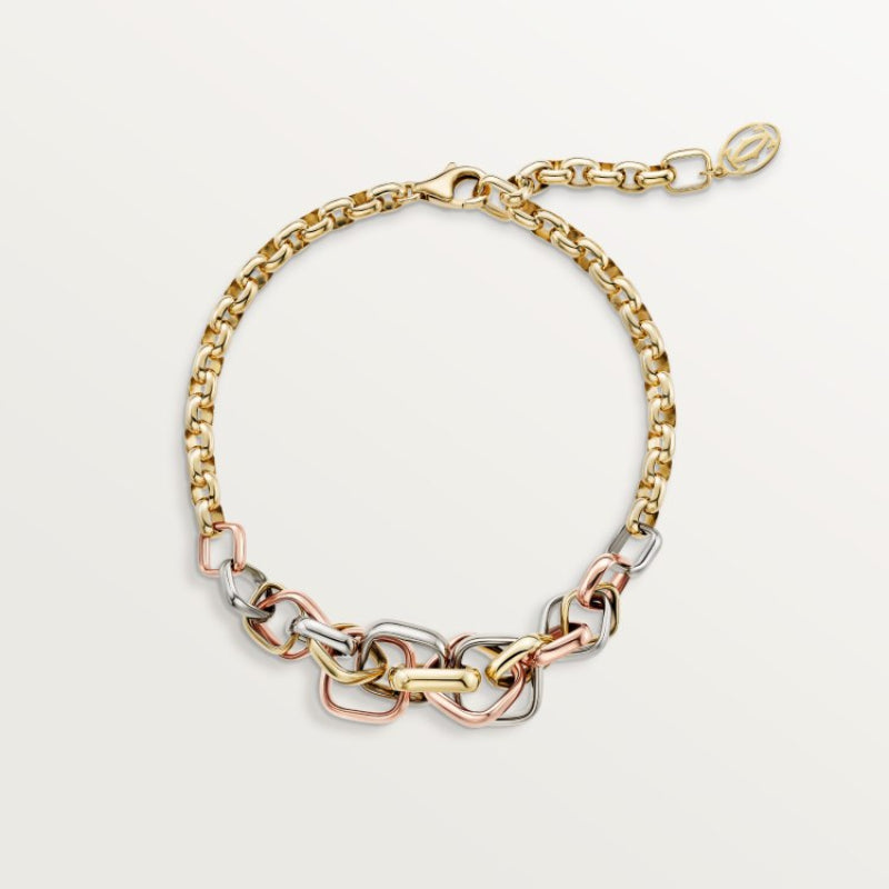 Gold, silver, and rose gold chain bracelet on a light gray background