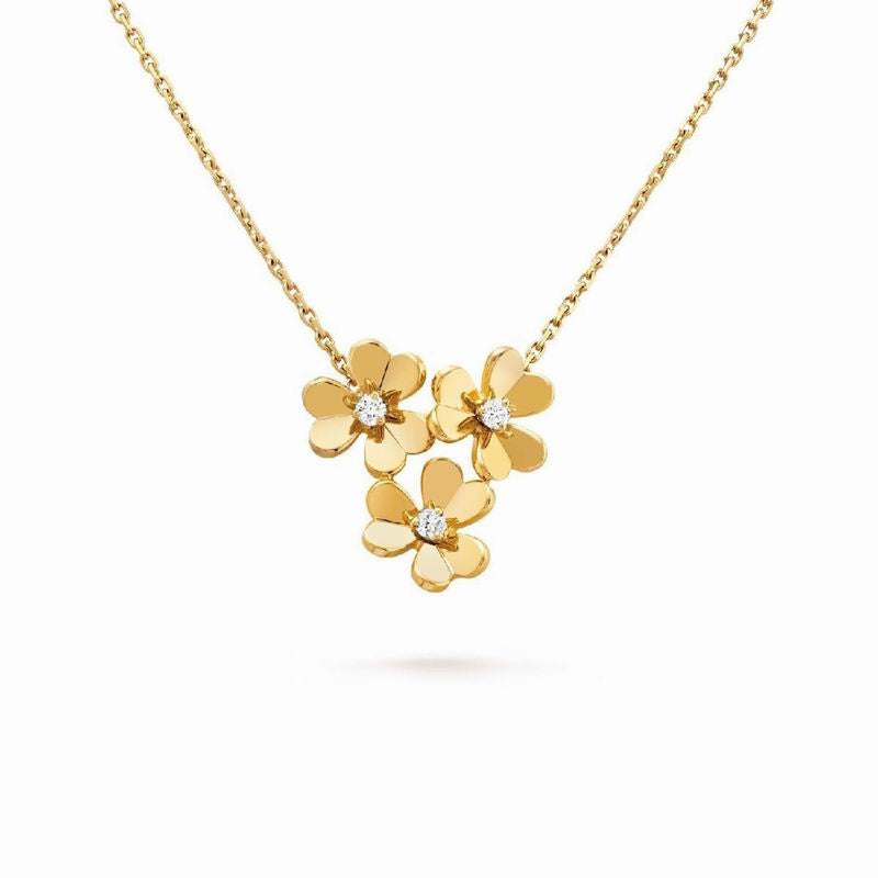 A gold necklace featuring three small flower charms, each with a tiny clear gemstone in the center, displayed against a solid white background.