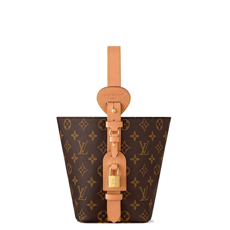 monogram canvas bucket bag with tan leather trim, a top handle, and a front strap closure secured by a gold padlock, shown on a plain white background.