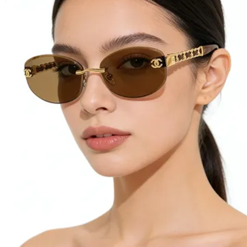 A close-up of a model wearing Chan sunglasses with gold-tone metal frames, brown tinted lenses, and signature interlocking C C logos on the temples.