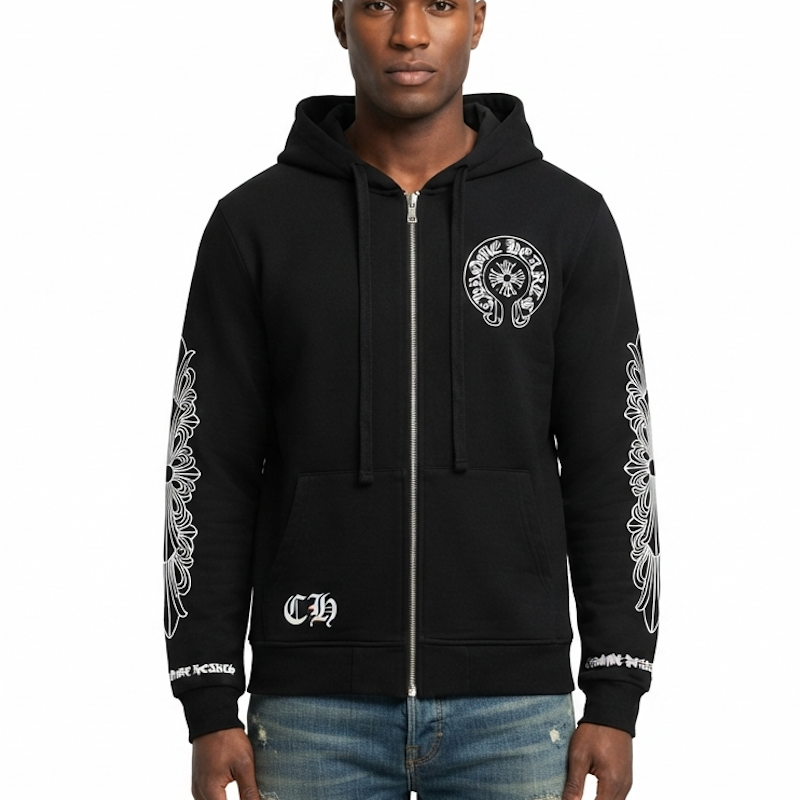 A man wearing a black full-zip hoodie with white graphic prints on the chest, sleeves, and lower front pocket, paired with blue jeans, against a plain white background.