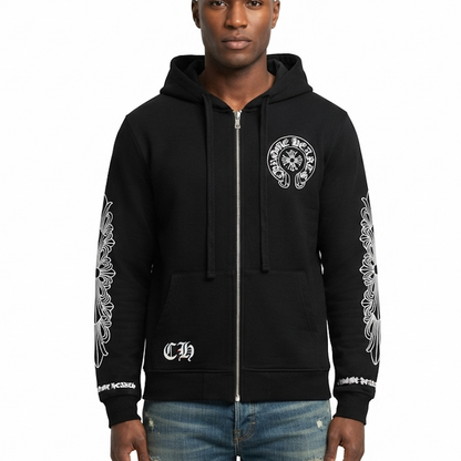 A man wearing a black full-zip hoodie with white graphic prints on the chest, sleeves, and lower front pocket, paired with blue jeans, against a plain white background.