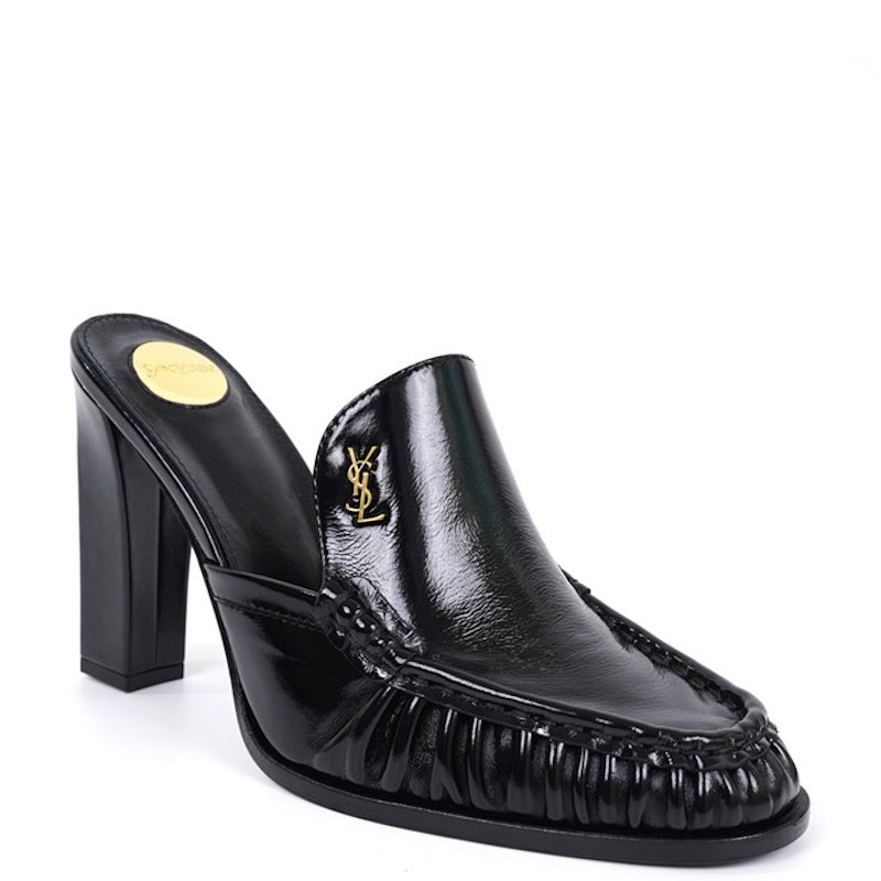 A black leather mule shoe with a block heel, featuring a gold-tone Y logo on the side and a gold insole, shown against a plain white background.