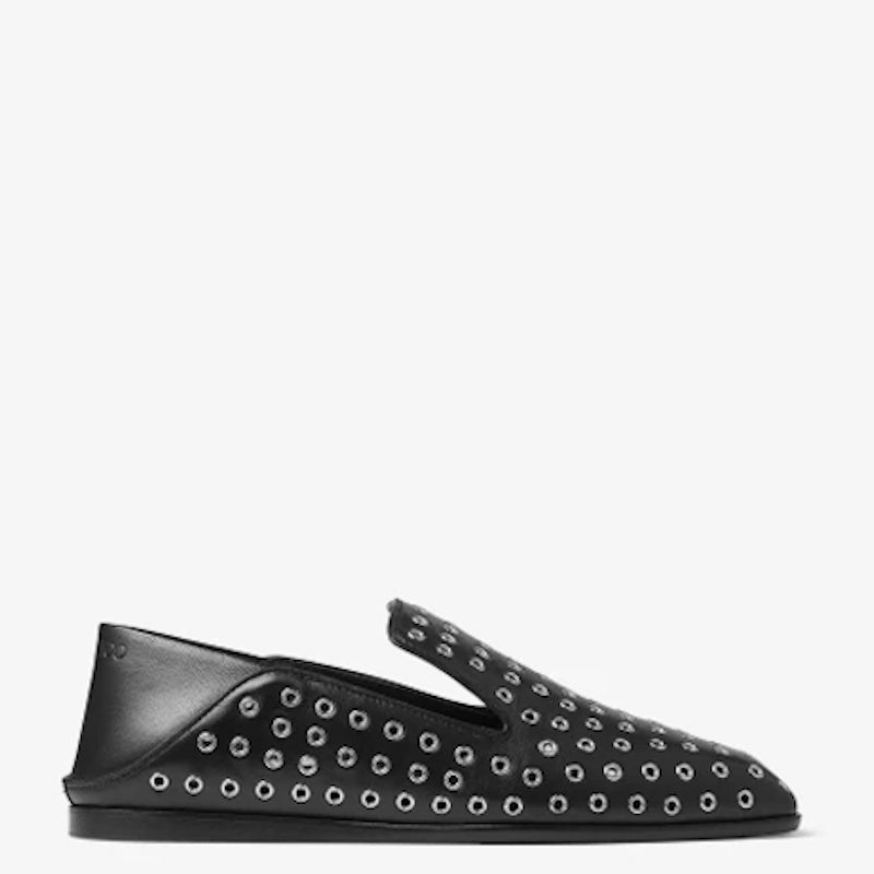 A black leather slip-on loafer with silver metal eyelet studs, shown in a side profile against a plain white background.