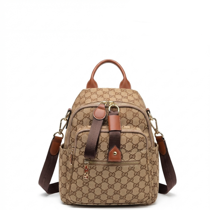 A GG Supreme canvas backpack in beige and brown, featuring tan leather top handles, a front zip pocket with a brown leather strap detail, and a detachable brown shoulder strap, shown against a plain white background.