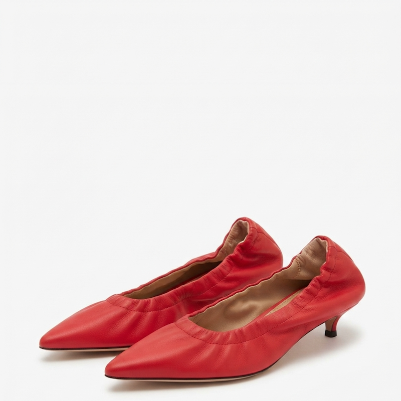 A pair of red pointed-toe kitten heels with gathered elastic detailing around the collar, shown on a clean white background.