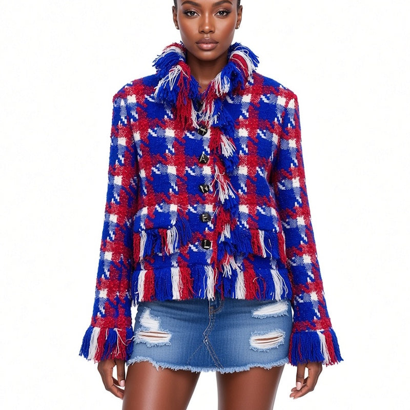 A model wearing a red, white, and blue plaid fringed tweed jacket with a high collar and distressed denim mini skirt against a plain white background.
