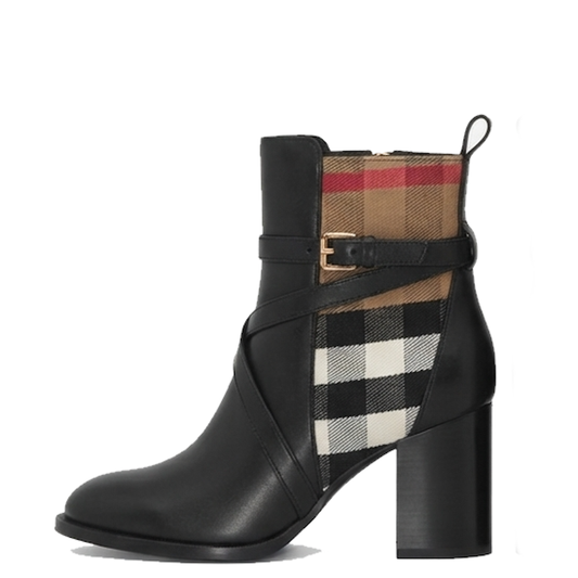 A black leather ankle boot with a chunky block heel, featuring a buckle strap across the side and a split plaid pattern in beige, black, white, and red on the shaft.