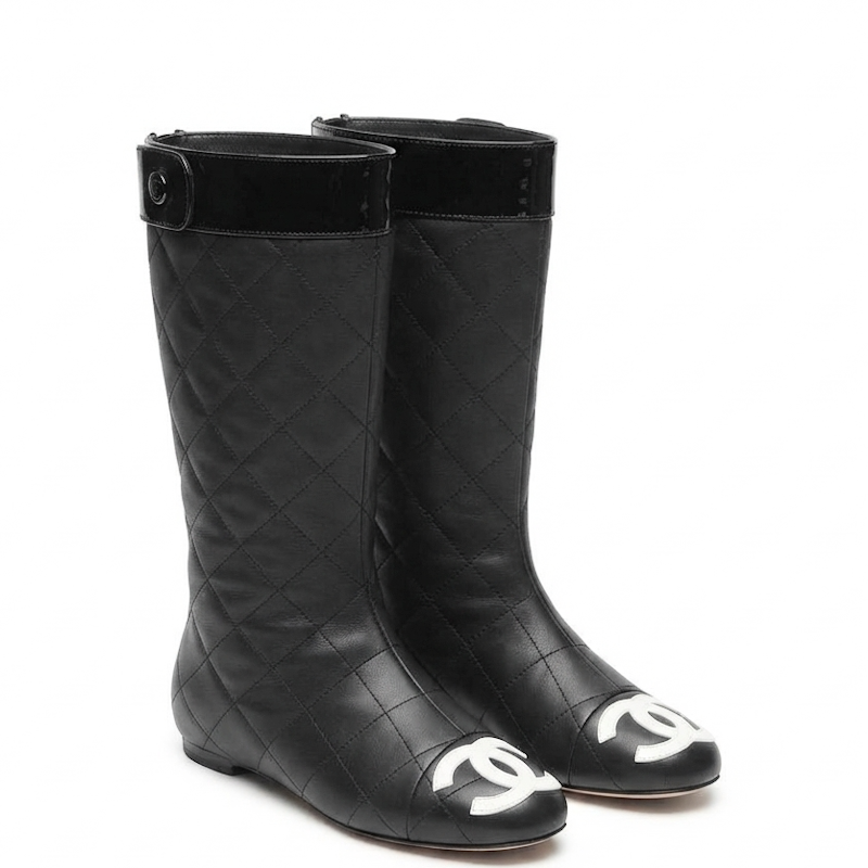A pair of black quilted leather boots with a glossy black velvet collar and a white interlocking CC logo on the toe, set against a plain white background.