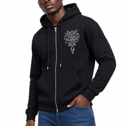 A man wearing a black zip-up hoodie with a white gothic-style graphic on the left chest, paired with blue jeans, against a plain white background.