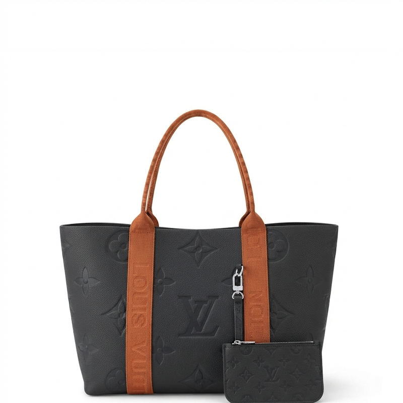  black monogram tote bag with brown leather handles and side straps, shown on a clean white background with a matching small pouch.