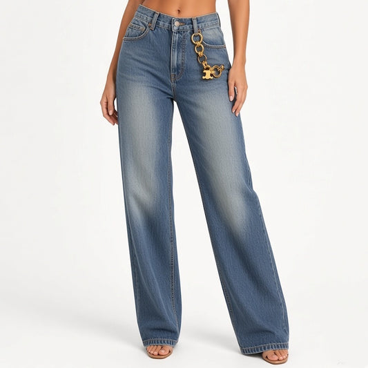 A model wearing a pair of wide-leg blue denim jeans with a gold-tone chain detail hanging from the front pocket, shown against a plain white studio background.