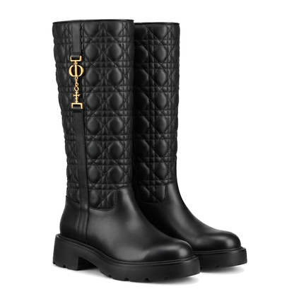 A pair of black quilted leather knee-high boots with a gold-tone logo charm on the side, set against a plain white background.