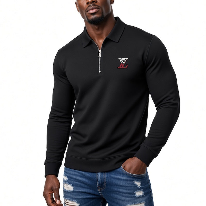 A man wearing a black long-sleeve quarter-zip polo shirt with a red and white embroidered logo on the left chest, paired with distressed blue jeans, against a plain white background.