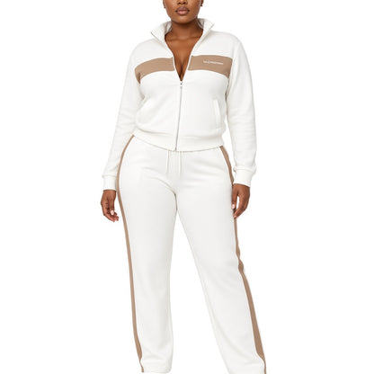 A woman modeling a white zip-up track jacket and matching sweatpants set with beige color-block panels on the chest and along the outer legs, shown against a plain white background.