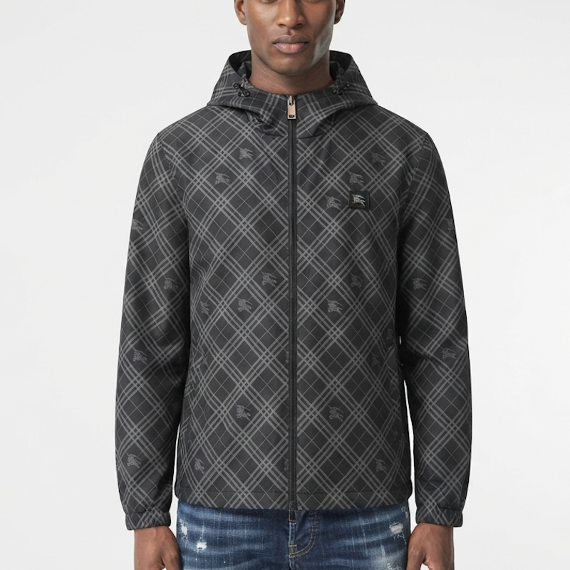 A man wearing a dark gray hooded zip-up jacket with a subtle diagonal plaid pattern, paired with blue jeans, against a plain white studio background.