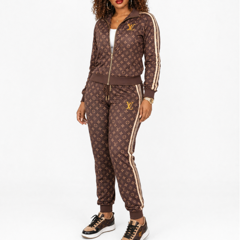 A model wearing a brown L monogram tracksuit with gold and white side stripes, featuring a zip-up jacket and matching jogger pants, paired with black and brown sneakers against a white studio background.