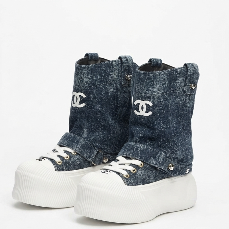 A pair of  high-top platform sneakers in washed blue denim with white chunky soles, white laces, and white embroidered Chanel logos on the side.