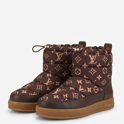 A pair of  quilted winter boots in dark brown with the signature monogram pattern in a dusty rose pink, featuring a thick brown leather sole.