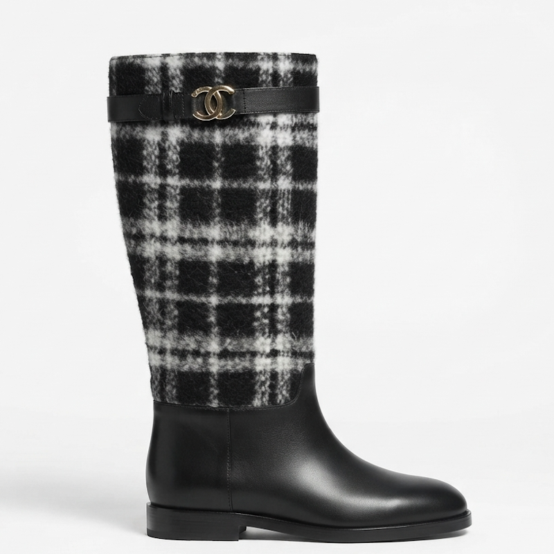 A knee-high boot featuring a black and white plaid wool upper and a smooth black leather lower section, accented by a black leather strap with a gold-tone interlocking CC logo buckle.