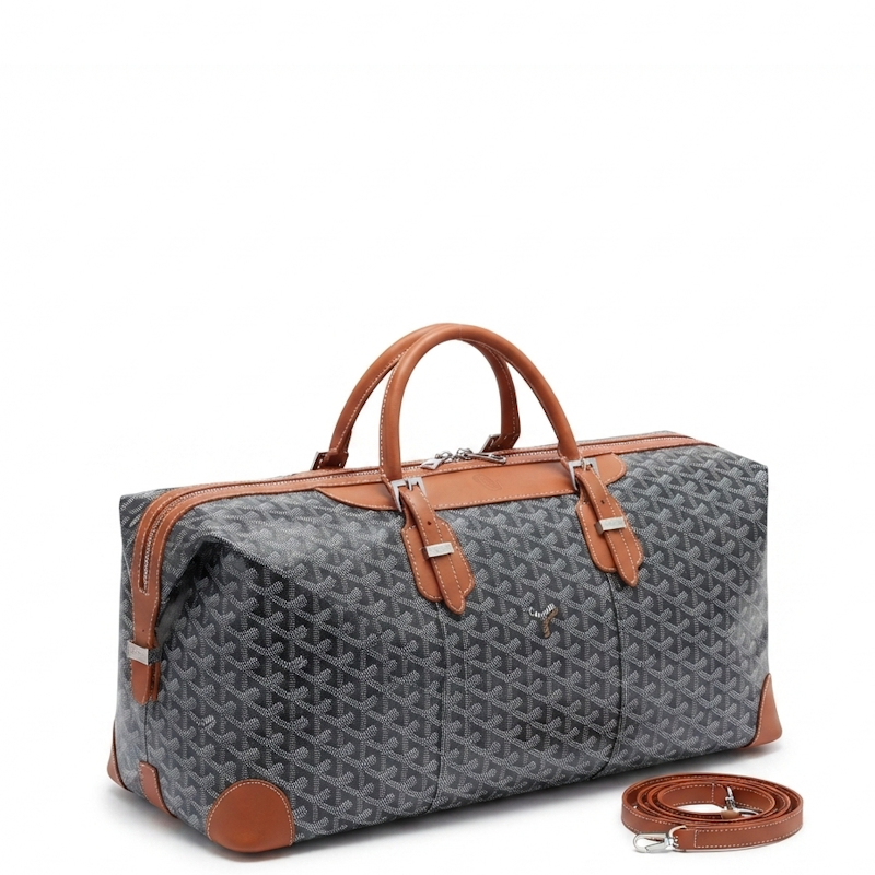 gray monogram duffel bag with tan leather handles, trim, and corner protectors, shown on a white background with its matching leather strap placed beside it.