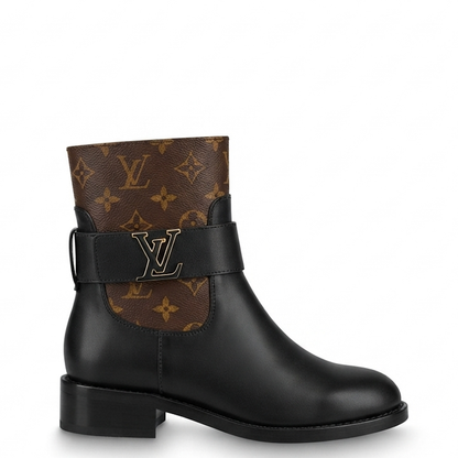 black leather ankle boot with brown monogram canvas side panels and a black strap featuring a gold-tone LV logo, shown on a white background.