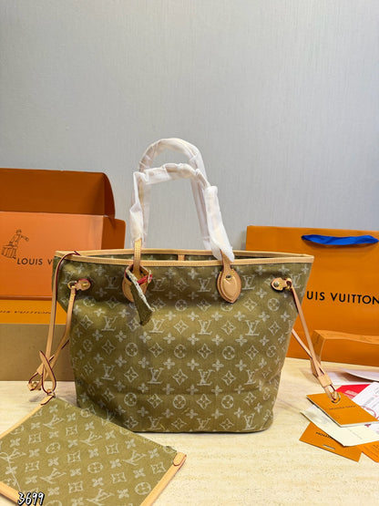 monogram canvas tote bag in olive green with beige leather trim and white protective paper wrapping on the handles, displayed with orange Louis Vuitton boxes and shopping bags in the background.