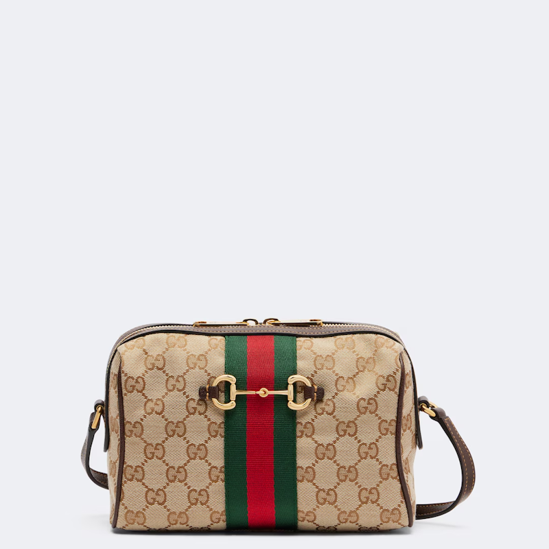  canvas shoulder bag in beige GG Supreme monogram with a central green and red web stripe and gold-tone horsebit hardware, shown on a light gray background.