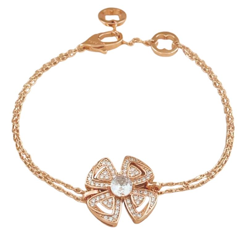 A delicate rose gold chain bracelet featuring a central four-leaf clover charm paved with small clear stones and set with a round clear center stone, shown on a plain white background.