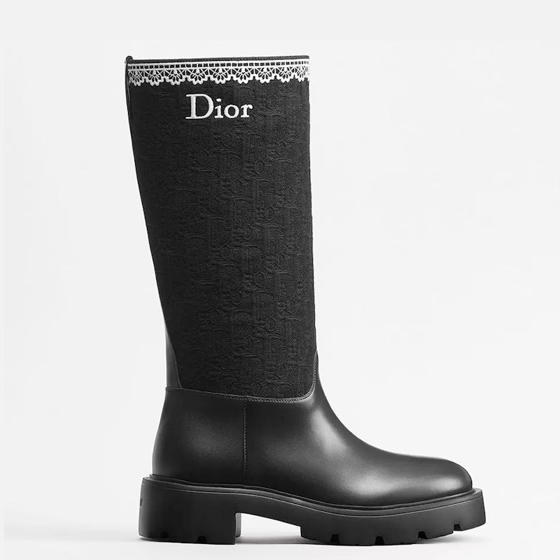 A single black  knee-high boot with a textured fabric shaft, white lace trim at the top, and the  logo printed in white, shown against a plain white background.