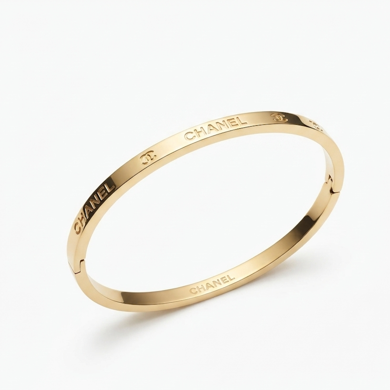A gold-toned  bangle bracelet with engraved CHA lettering, shown on a clean white background.