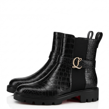 A pair of black ankle boots featuring a crocodile-embossed texture, elastic side panels, a decorative strap with a gold-tone 'CL' logo, and chunky lug soles, shown against a plain white background.
