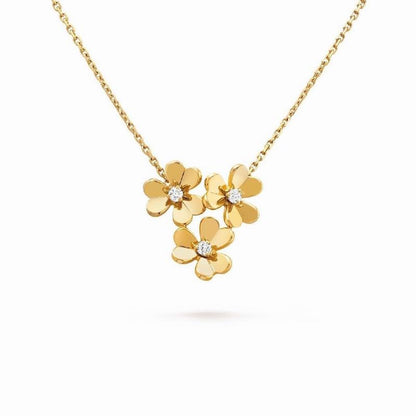 A gold necklace featuring three small flower charms, each with a tiny clear gemstone in the center, displayed against a solid white background.
